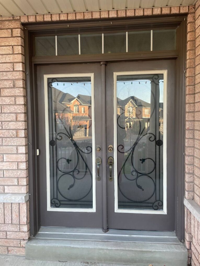 Before – traditional double front doors with decorative glass and grills on a brick home in Woodbridge.