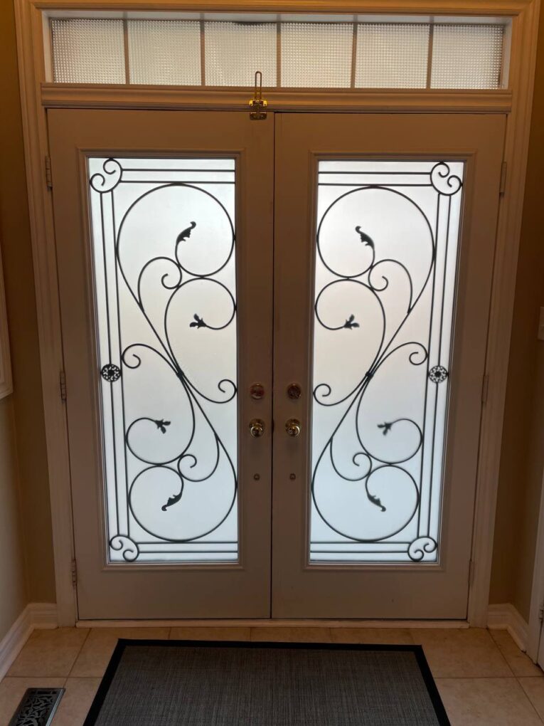 Interior view of the original double doors with frosted decorative glass panels and transom window.