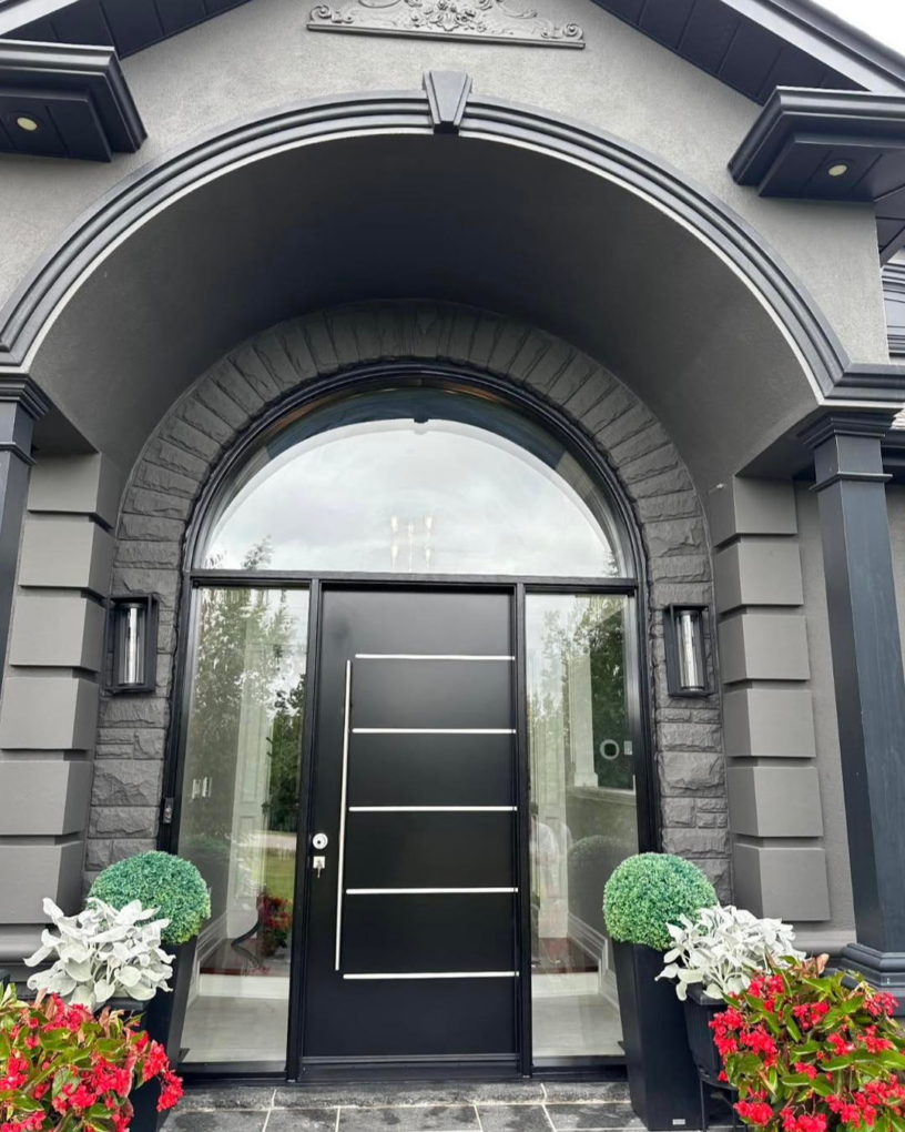 Exterior view of a modern matte black front door with arched transom and full-height sidelights on a GTA home