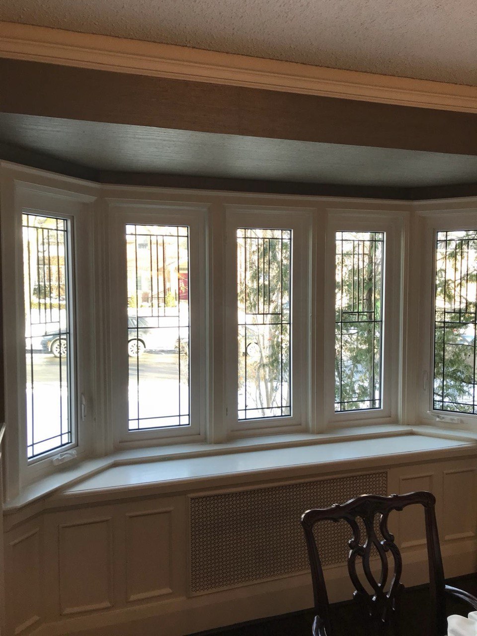 Interior-view-of-the-same-five-panel-bow-window-with-white-frames-decorative-glass-and-a-built-in-window-seat