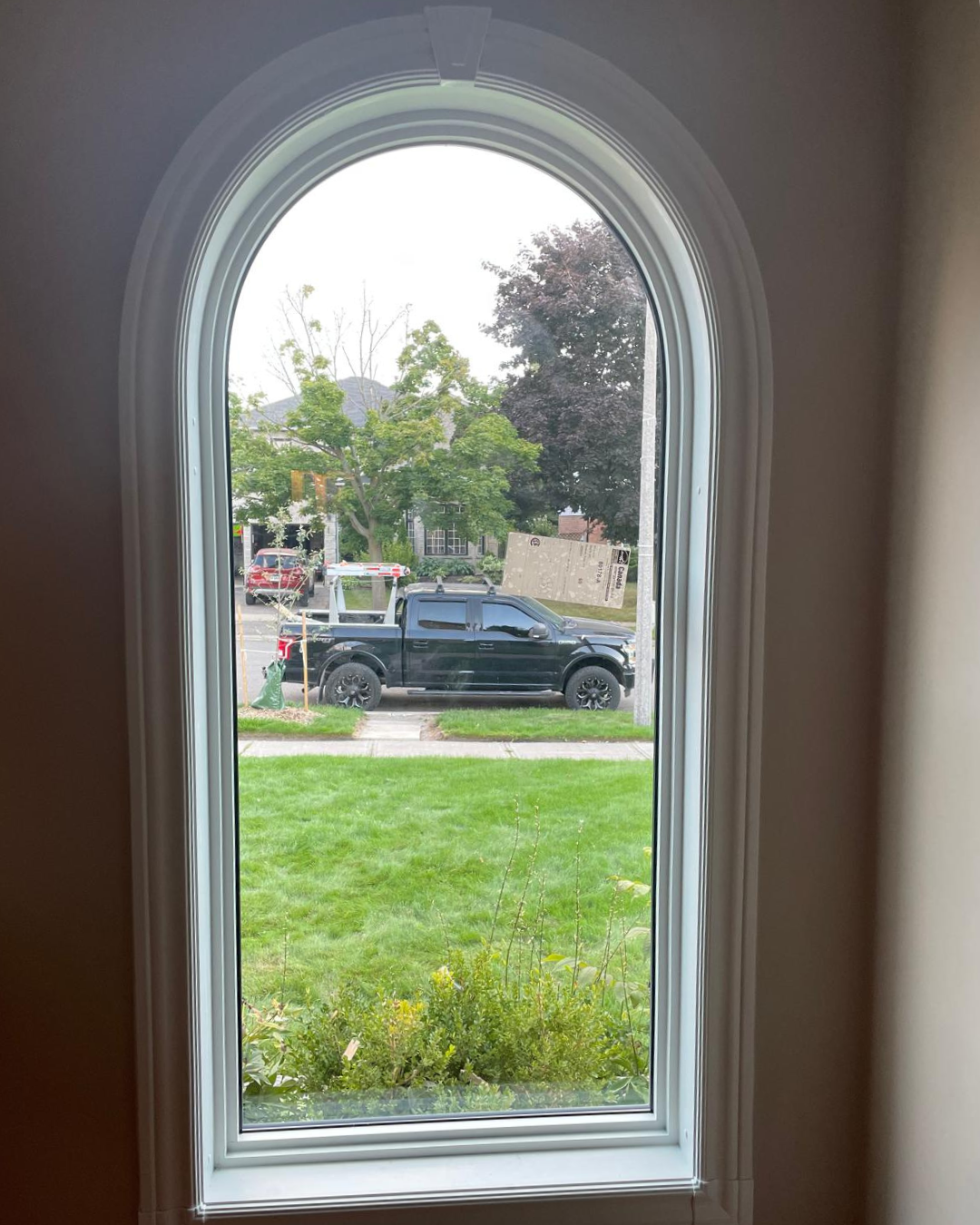 Tall narrow interior arched window with street view