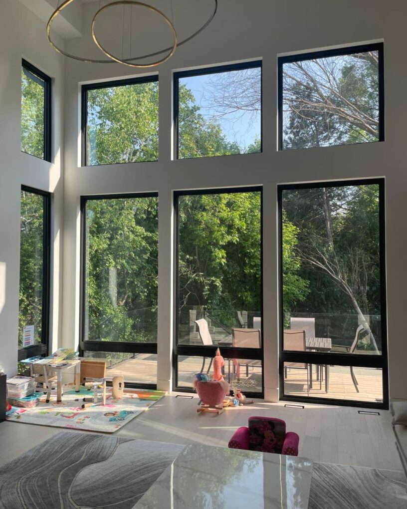 Floor-to-ceiling window wall in a Toronto living room bringing in natural light across two levels.