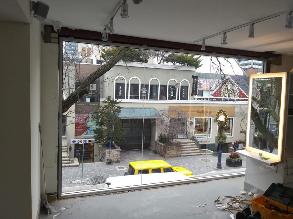 Commercial frameless glass windows installed on a brick building in Yorkville, Toronto