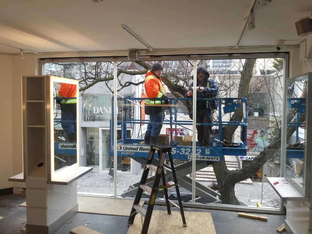 Large frameless tempered glass window with door for a Yorkville retail storefront