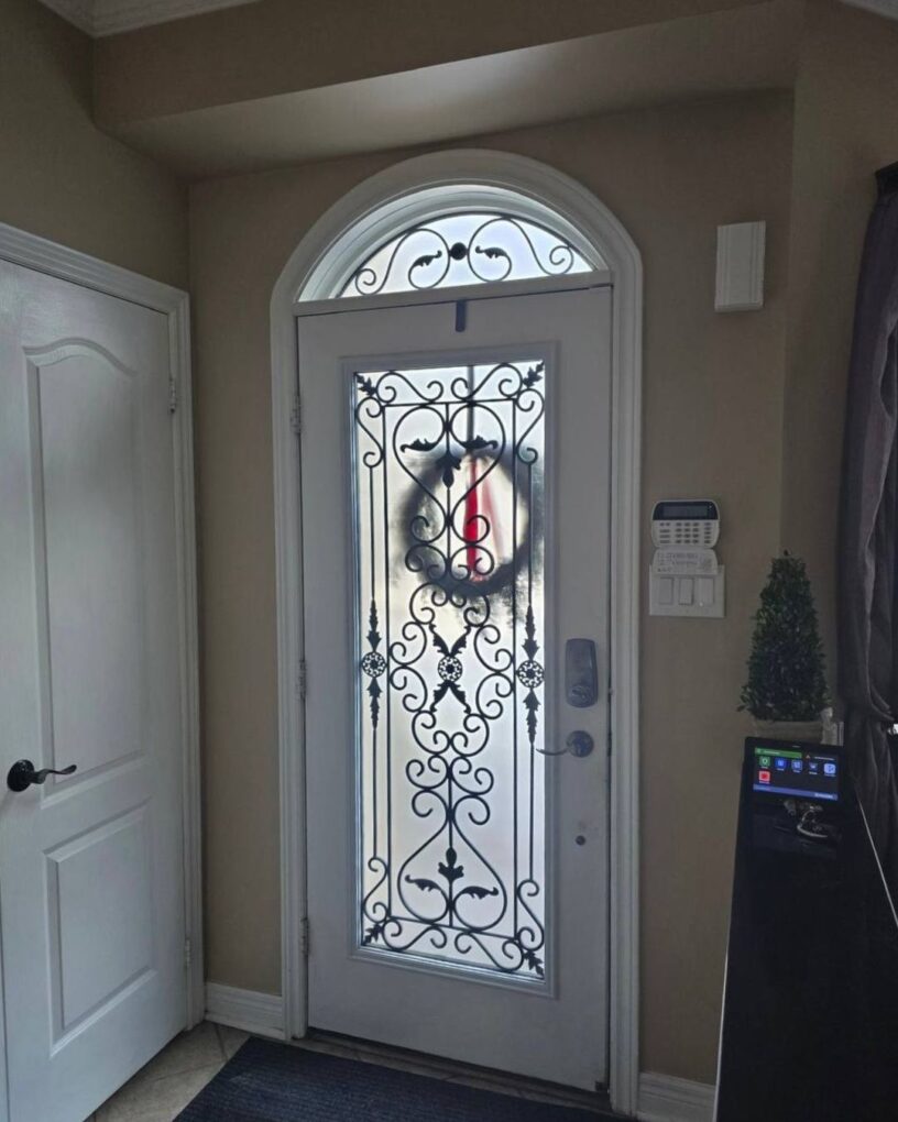 Interior view after installation of a custom arched fiberglass entry door in Oakville, with more natural light coming through the large grid glass insert