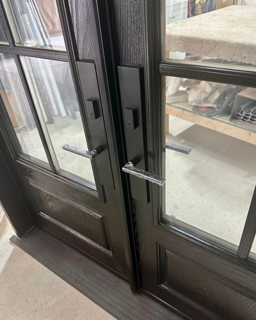 Close-up of black entry door handles and hardware before shipping