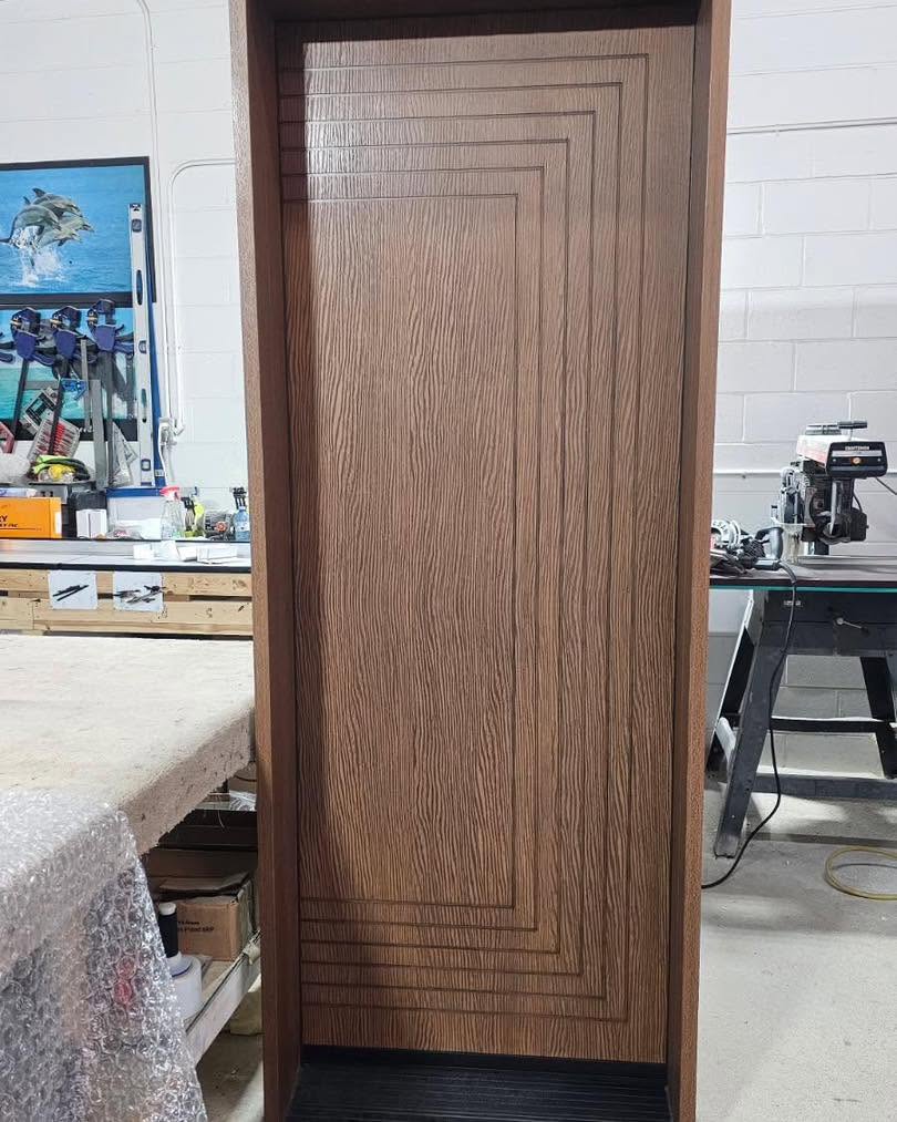 Dark woodgrain fiberglass entry door with rectangular grooving and matching frame